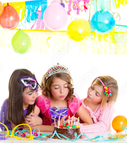children happy girls blowing birthday party cake