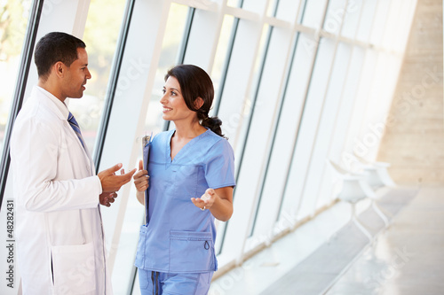 Medical Staff Having Discussion In Modern Hospital Corridor