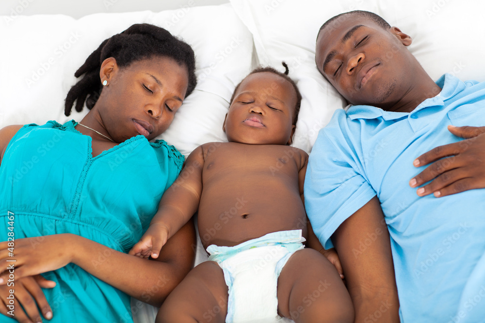 young african american couple napping with baby boy