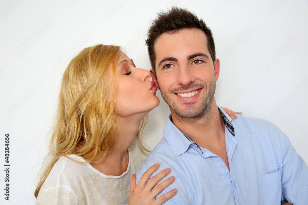 Girl kissing boyfriend on white background Girl kissing boyfriend on white background