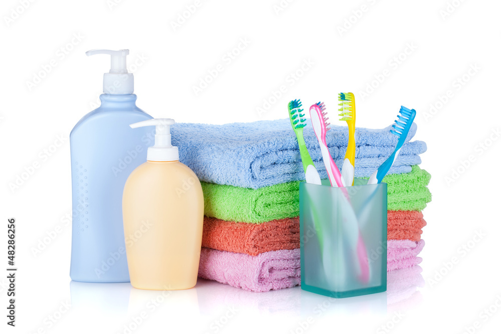 Four colorful toothbrushes, cosmetics bottles and towels Four colorful toothbrushes, cosmetics bottles and towels