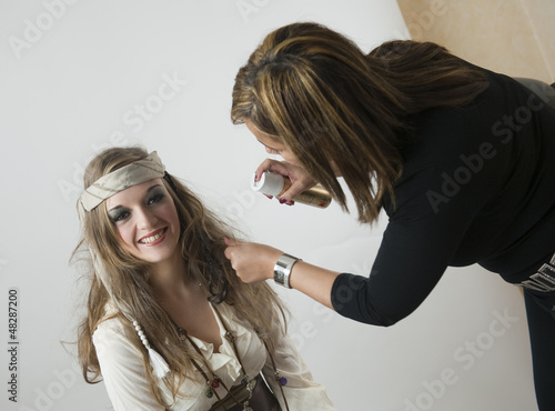 Billede på lærred Coiffeuse coiffant une jeune femme en pirate
