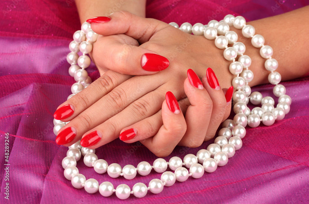 Female hands holding beads on color background Female hands holding beads on color background