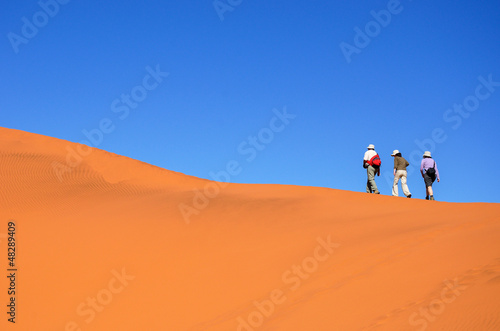 People walking on dune of Namib desert  hiking in South Africa