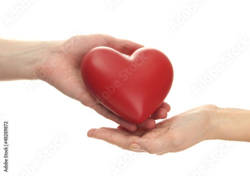 Red heart in woman and man hands  isolated on white