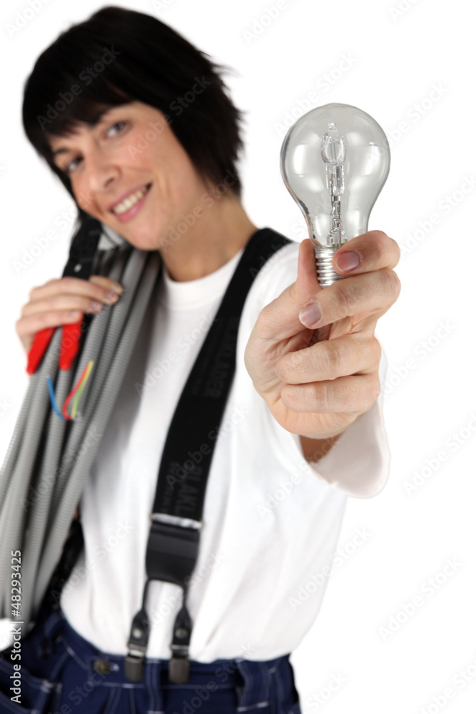 Female electrician showing light bulb Female electrician showing light bulb