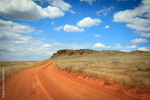 Dirt road orange prairie, going to the blue sky © Aleksandr Kurganov