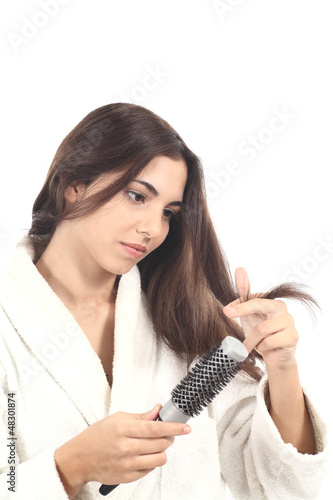 Beautiful woman with a hairbrush watching her hair