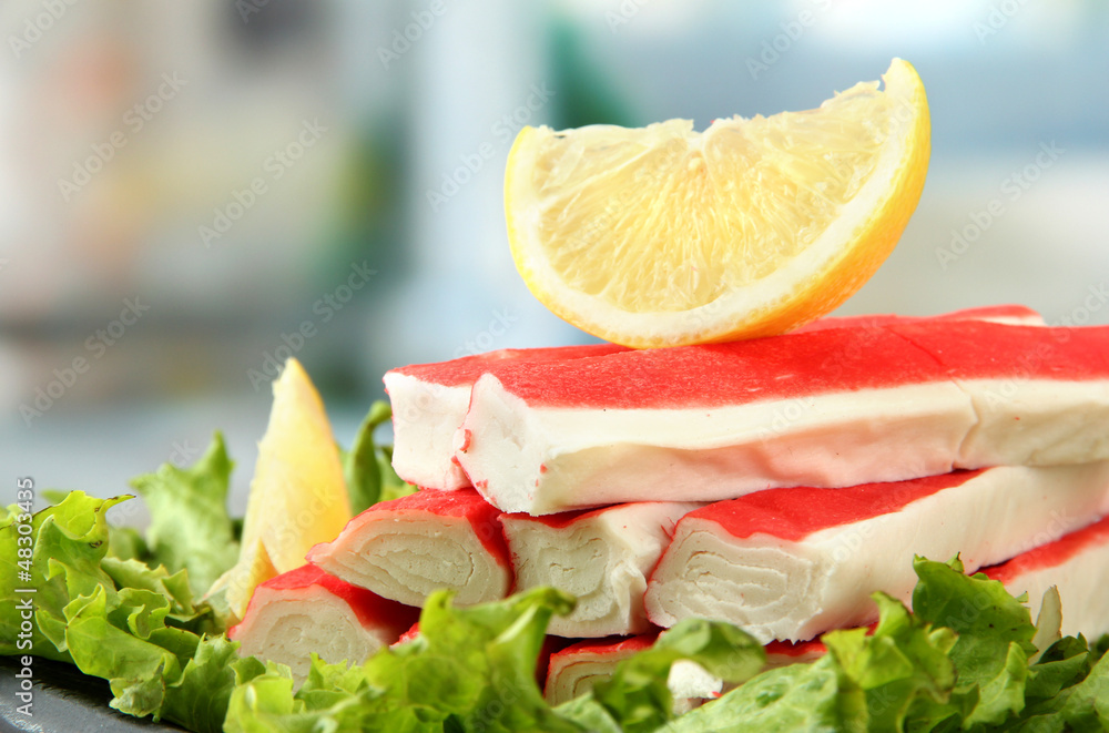 Crab sticks with lettuce leaves and lemon, close up Crab sticks with lettuce leaves and lemon, close up