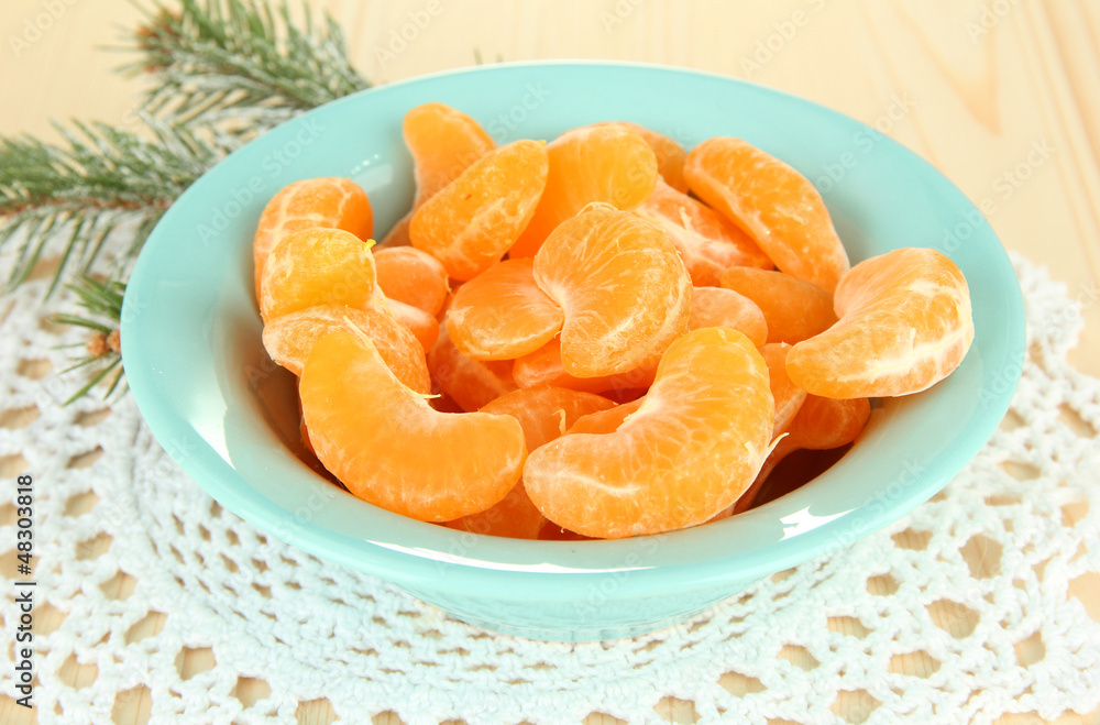 Tasty mandarine's slices on color plate on light background Tasty mandarine's slices on color plate on light background