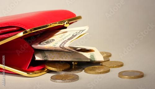 female red wallet with money on grey background