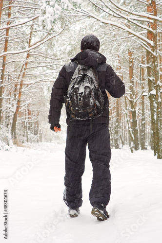 The man walking in winter forest