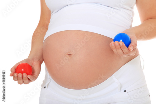 Schwangere Frau hält roten und blauen Ball