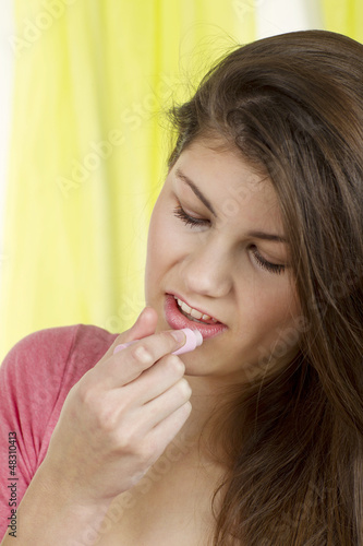 H  bsche junge Frau verwendet einen Lippenpflegestift
