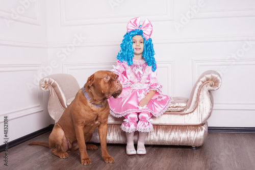 Cute girl dressed like Malvina with dog posing on sofa photo