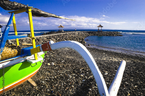Outrigger fishingboat on the beach in Candidasa, Bali photo