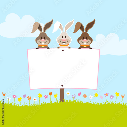 3 Bunnies Holding Easter Egg Label In Meadow