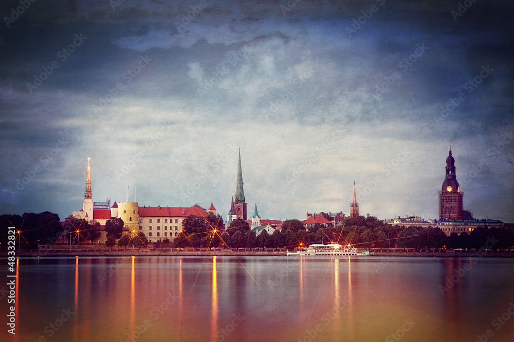 Retro style photo of night Riga cityscape