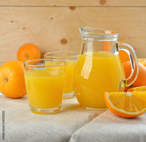 Natural orange juice in a jug on a white table