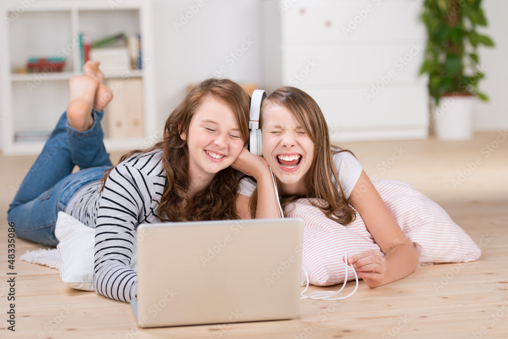 zwei freundinnen hören musik mit laptop zwei freundinnen hören musik mit laptop