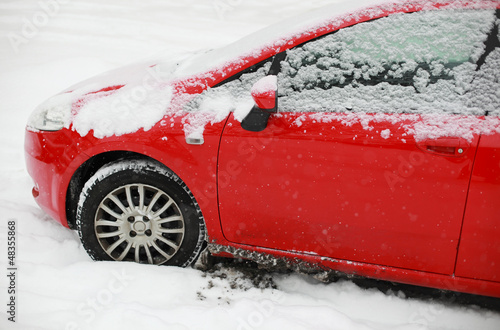 Red snow covered car in winter photo
