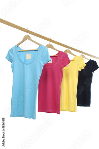 Four colorful shirt hanging on wooden hangers