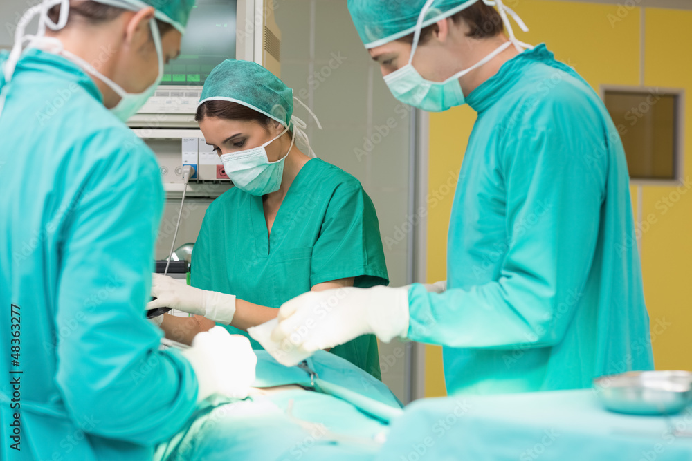 Surgeons working on a patient with his teams Surgeons working on a patient with his teams