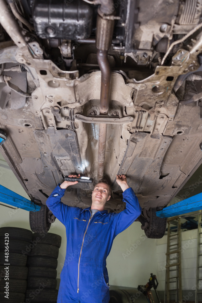 Portrait of mechanic working under car Portrait of mechanic working under car