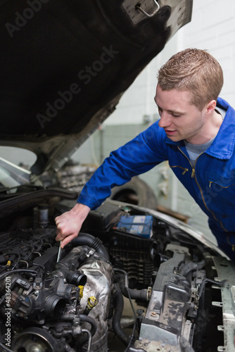 Car mechanic working on engine