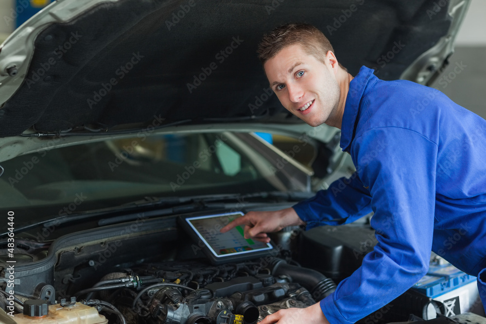 Confident mechanic using digital tablet Confident mechanic using digital tablet