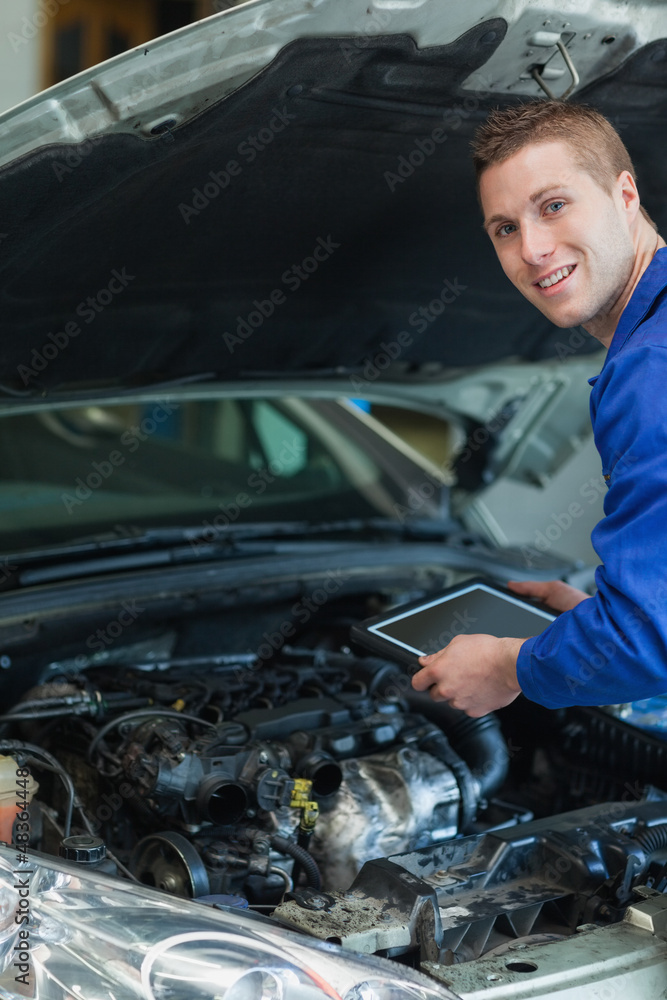Happy mechanic holding tablet pc Happy mechanic holding tablet pc