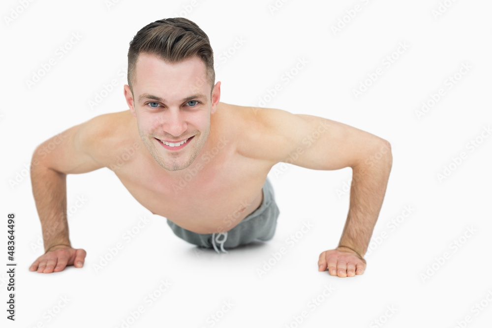 Portrait of happy shirtless man doing push ups Portrait of happy shirtless man doing push ups
