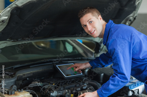 Confident mechanic using digital tablet