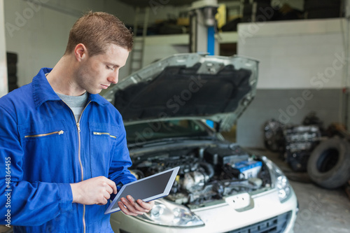 Auto mechanic working on tablet pc