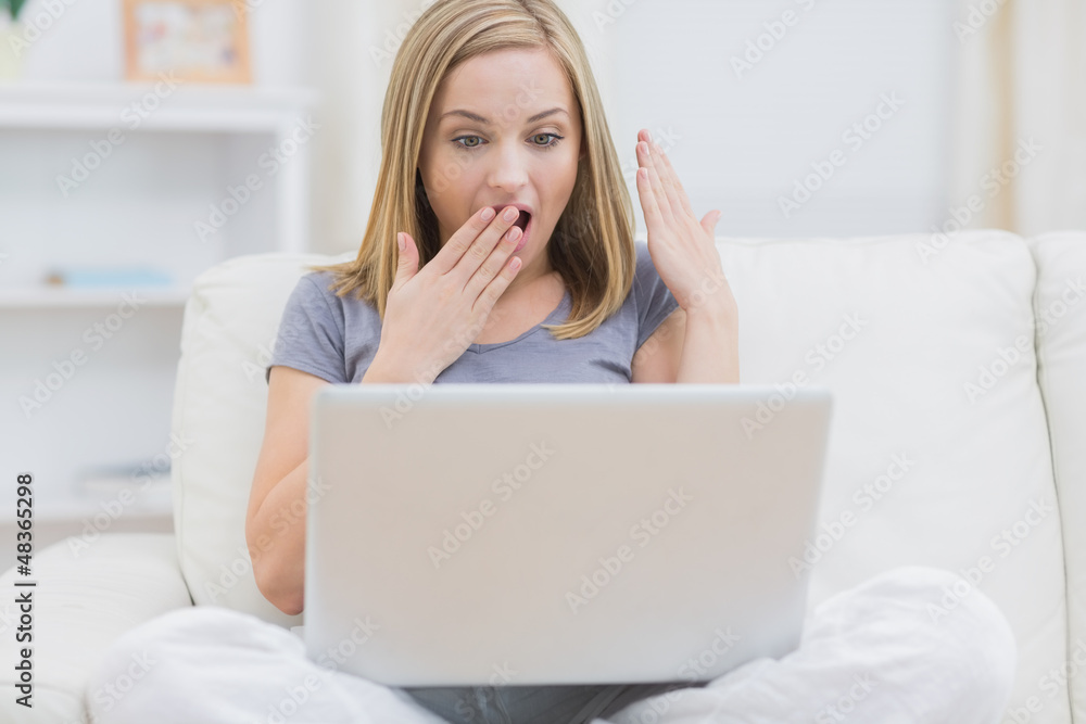Surprised casual woman using laptop at home Surprised casual woman using laptop at home