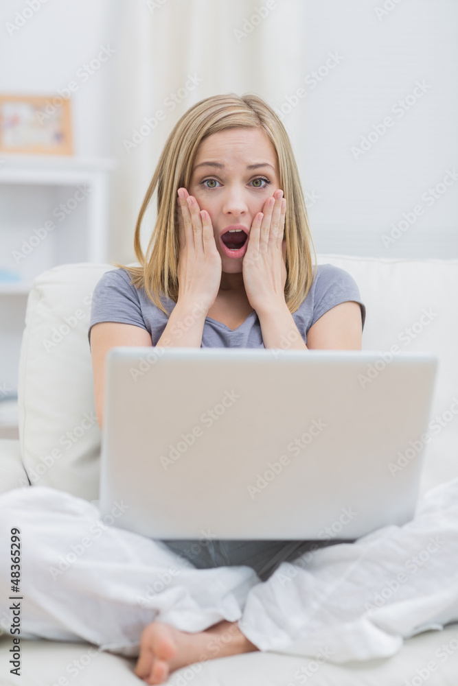 Portrait of shocked casual woman with laptop at home Portrait of shocked casual woman with laptop at home