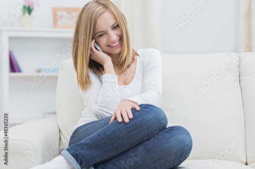 Casual happy woman using cellphone at home