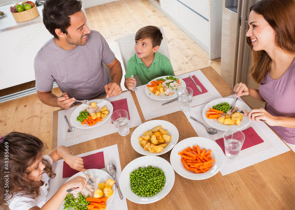 Family smiling around a healthy meal