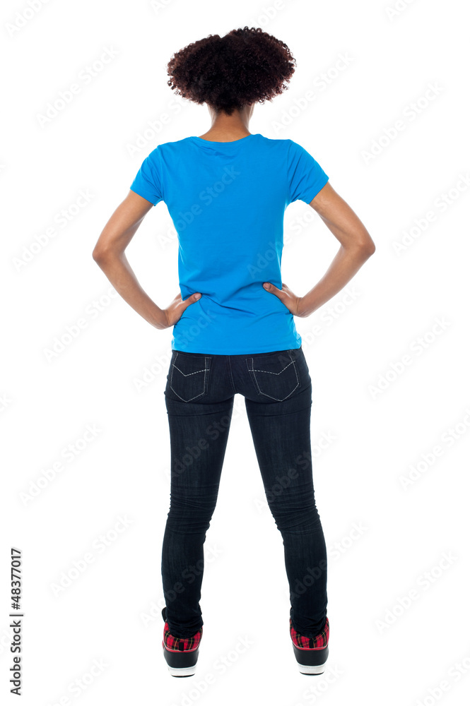 Back pose of young woman facing wall Back pose of young woman facing wall