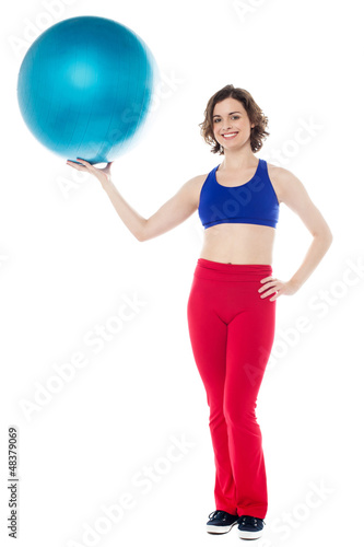 Lady gym instructor holding pilates ball