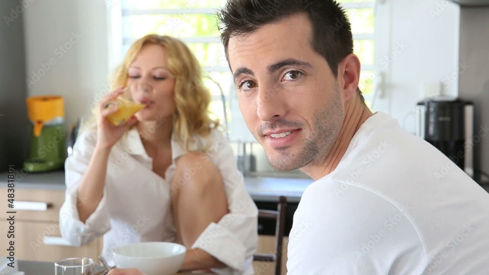 Young couple having breakfast in home kitchen Young couple having breakfast in home kitchen