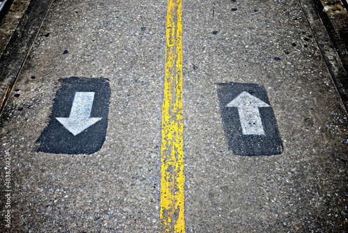 Two way sign on concrete walkway