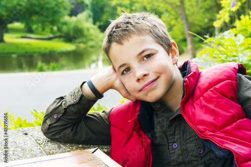 Cute teenage boy smiling against green background