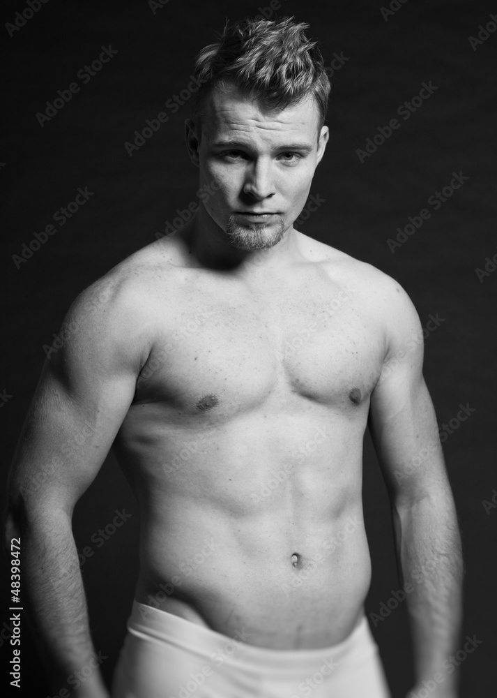 Muscled fitness man. Black and white studio shot. Muscled fitness man. Black and white studio shot.