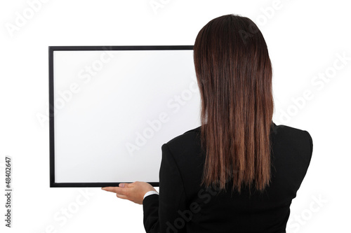 Woman back at the camera holding a frame.
