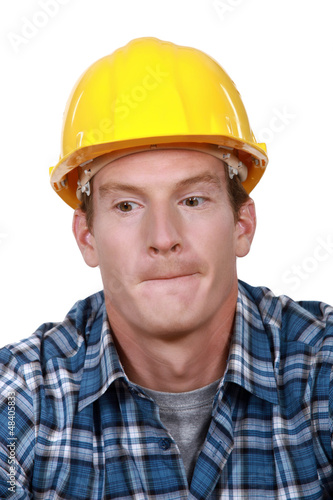 A portrait of a construction worker biting his lips.