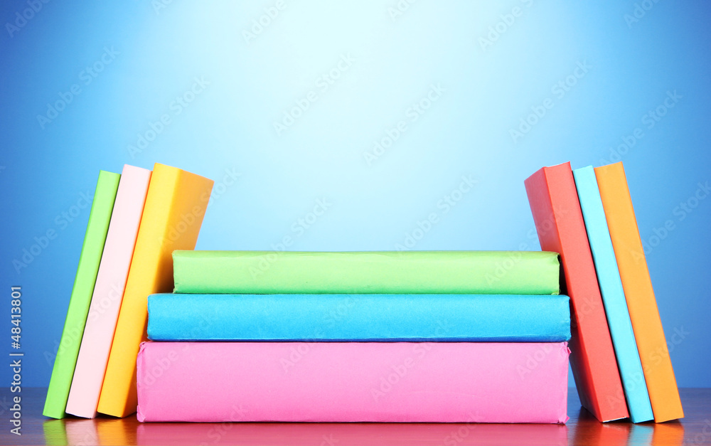 Stack of multicolor books on blue background Stack of multicolor books on blue background