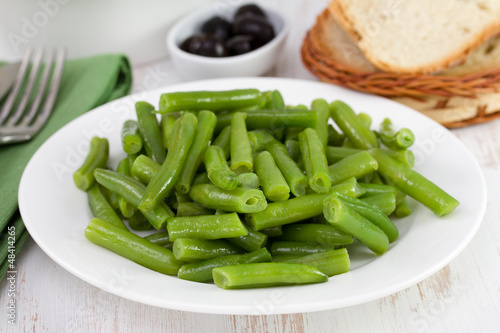 boiled beans on the plate with olives and bread