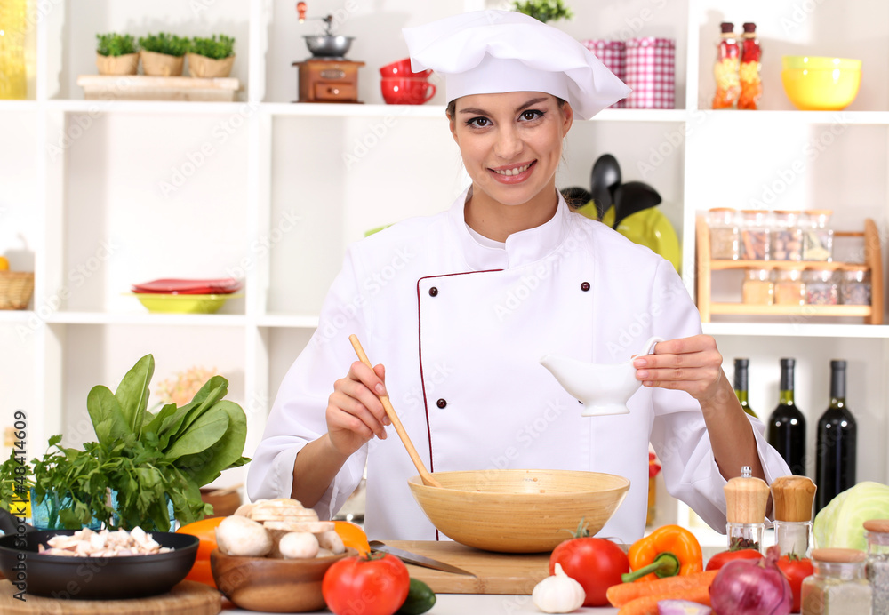 Young woman chef cooking in kitchen Young woman chef cooking in kitchen