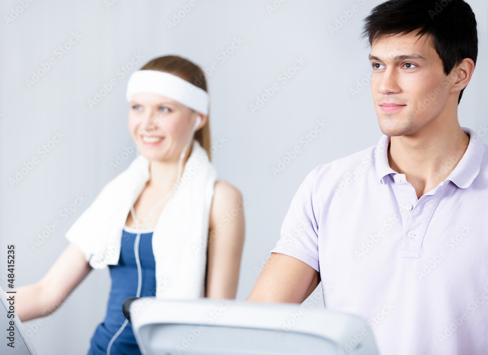 Fototapeta premium Young woman in sportswear training on gym